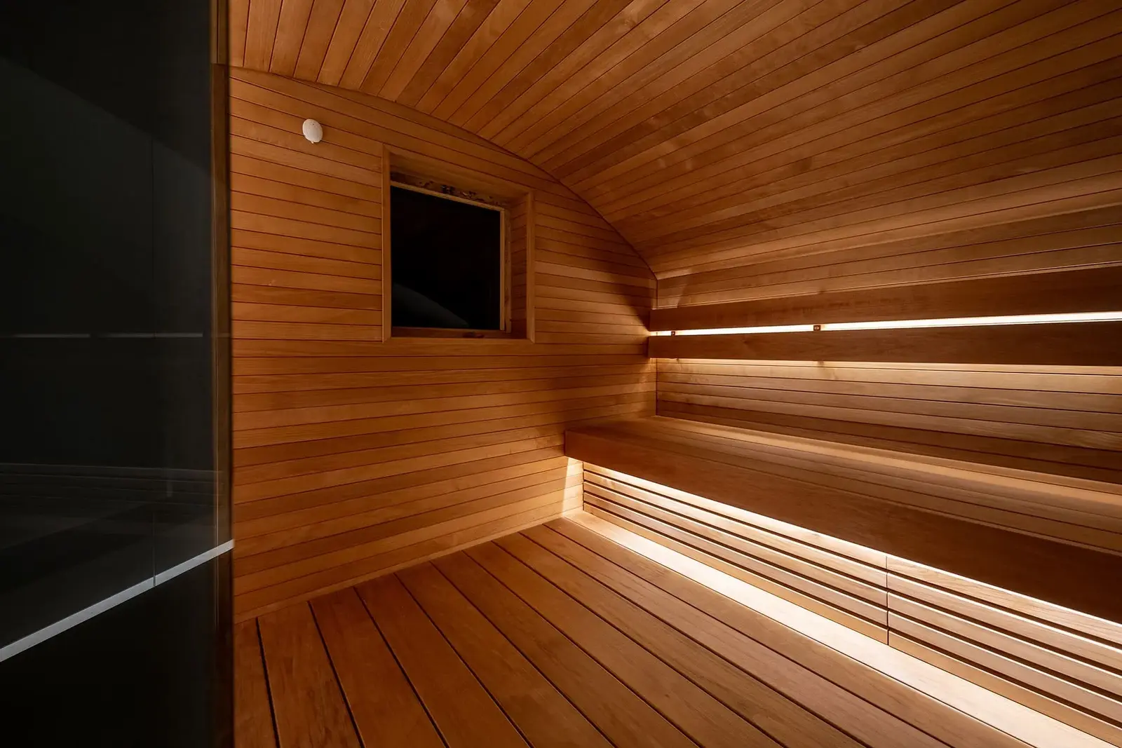 Completed sauna lined with horizontal Thermory STS4 thermo-aspen cladding and matching benches